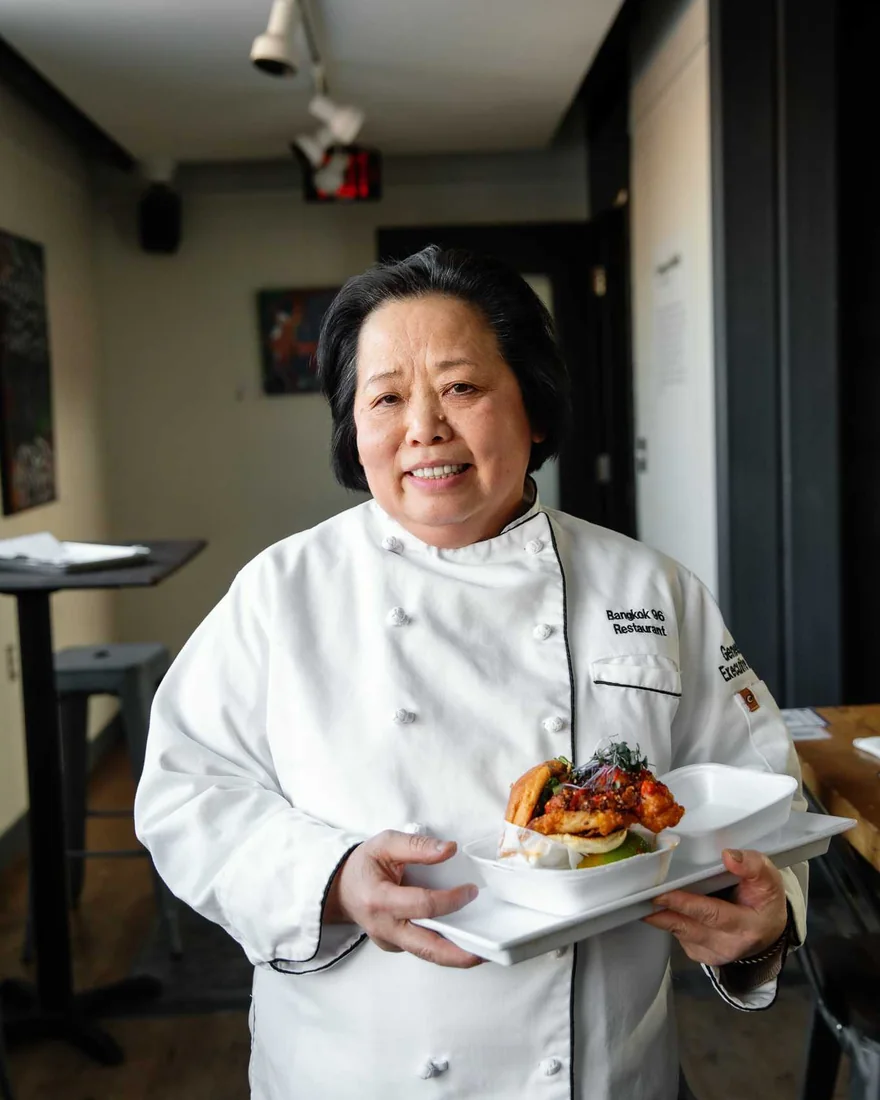 Chef Genevieve Vang holding a plate of Thai street food at Bangkok 96