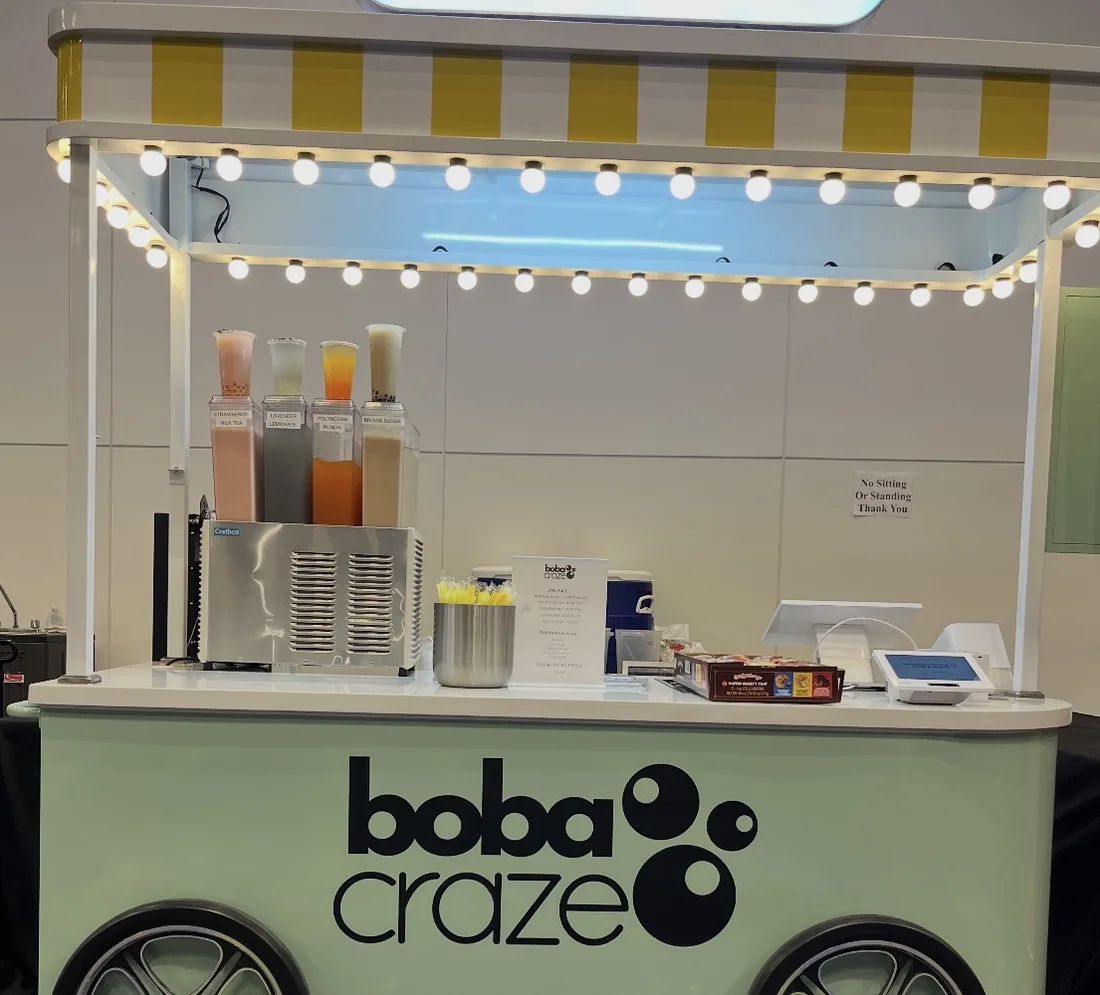 The Boba Craze mobile cart set up at an event, with drink dispensers and a full serving
counter