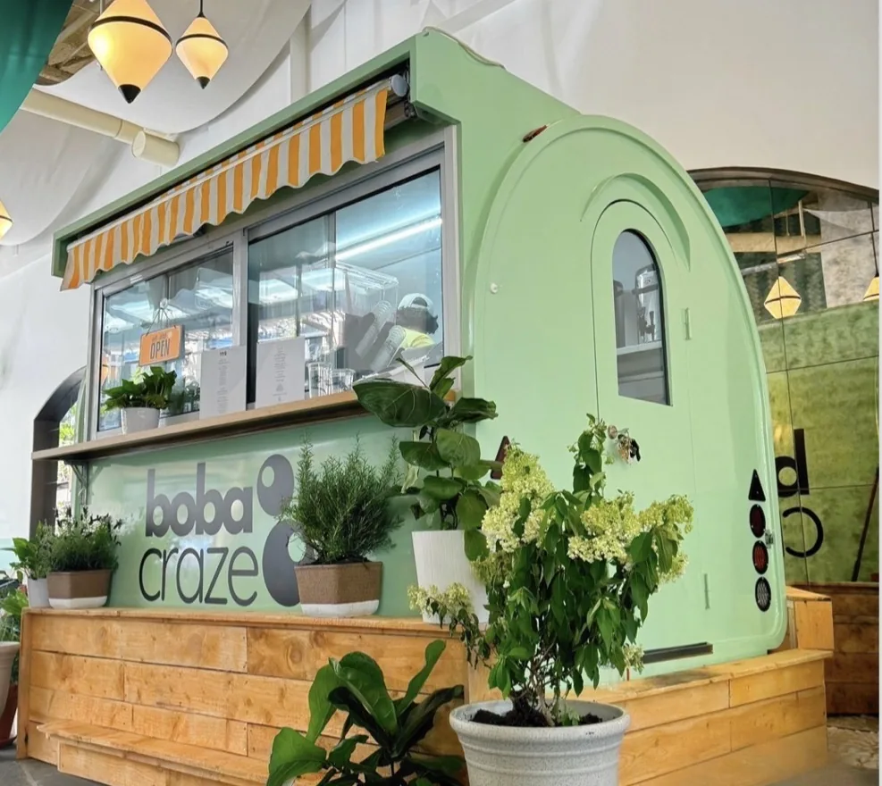 The mint green Boba Craze trailer with its striped awning and service window