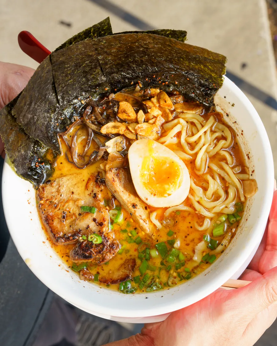 A bowl of Ichi-Kaku ramen held in two hands