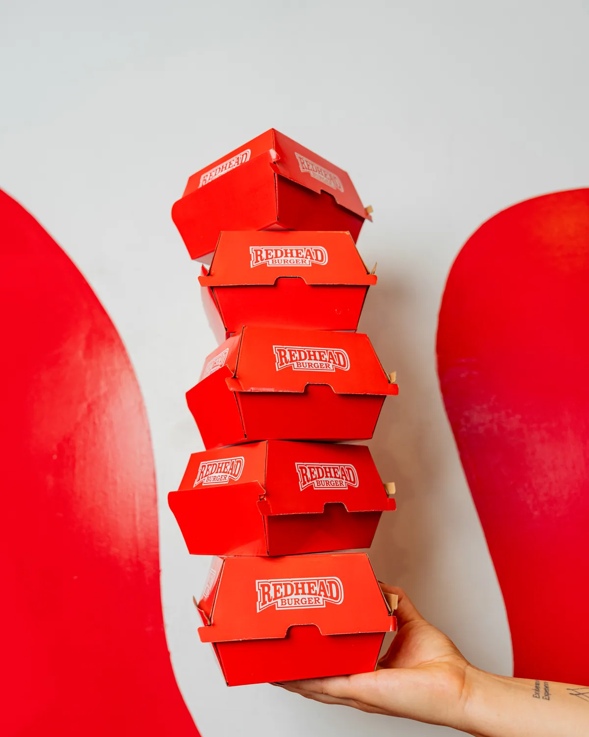 A stacked tower of Redhead Burger catering boxes