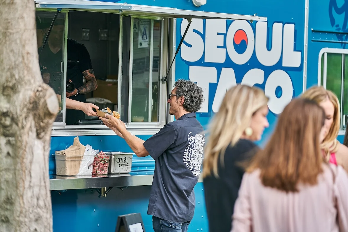 Guest receiving food at the Seoul Taco truck window