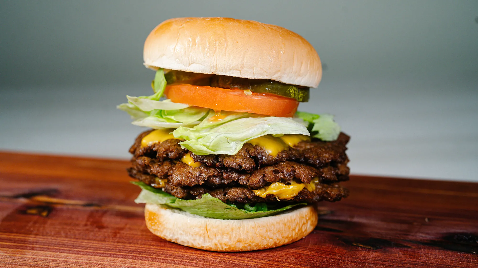 A double smash burger with melted cheese, lettuce and tomato at Smash Mouth Foods