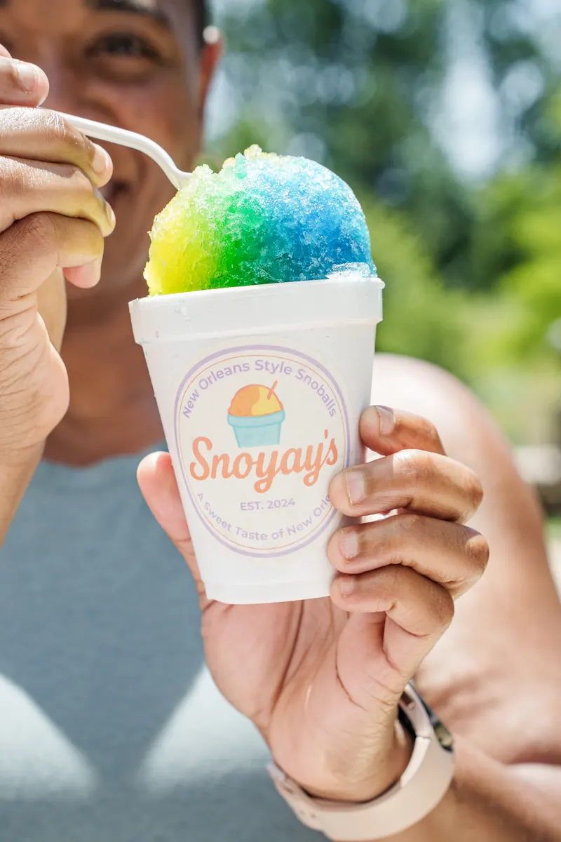 A guest holding up a rainbow snoball in a Snoyay&rsquo;s cup