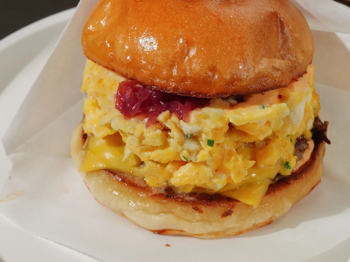A breakfast handheld on a toasted brioche bun