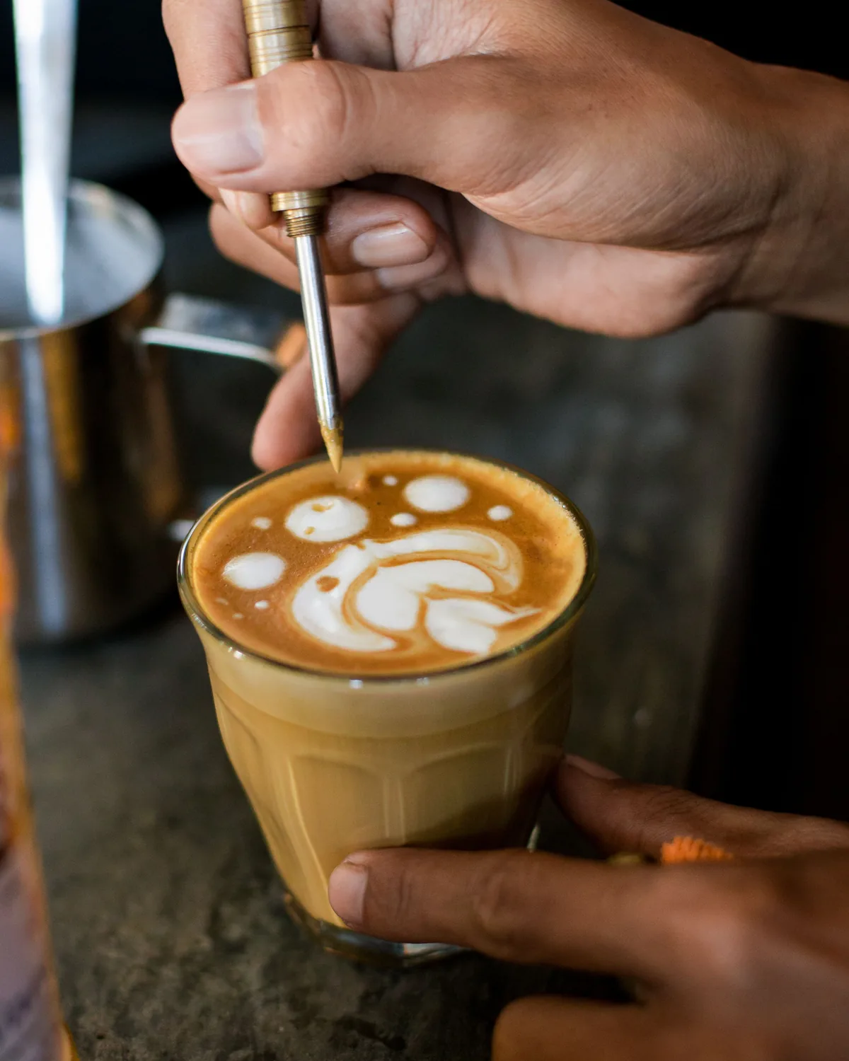 Latte art finished by hand over house-roasted espresso